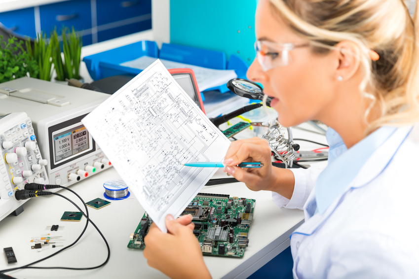 Female electronic engineer checking electronic circuit in laboratory